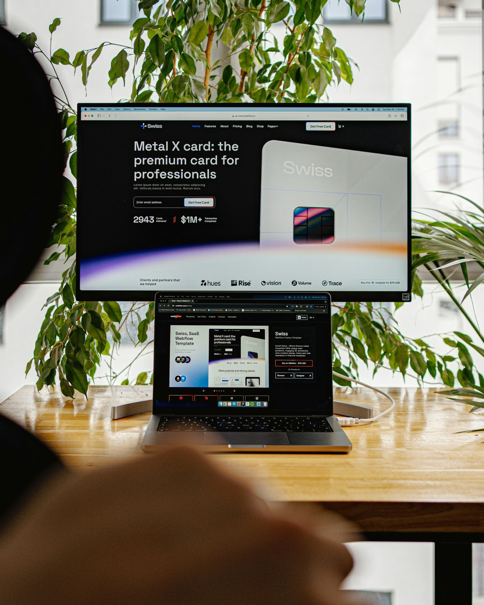 Moderner Arbeitsplatz mit Laptop und großem Bildschirm, auf denen Webdesign gezeigt wird.